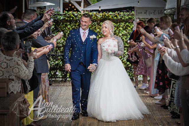 Confetti photo of smiling bride and groom at The Oaklands Hotel Norwich