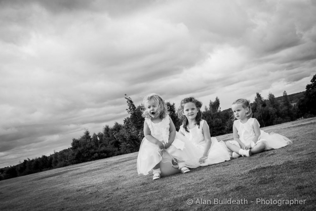 Young Bridesmaids sitting on grass at Wensum Valley Hotel Norwich NR8 6HP