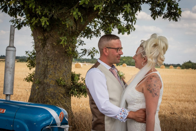 Bride and Groom with tractor in front of field Caston Norfolk