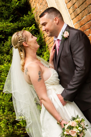 Bride and Groom posing for a photo outside at a church in Norwich