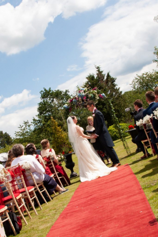 Bride and Groom getting married outside with red carpet at Norfolk Venue