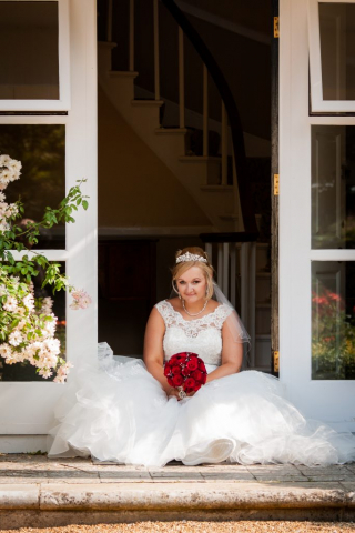 Bride sitting in doorway Park Farm Hotel Hethersett