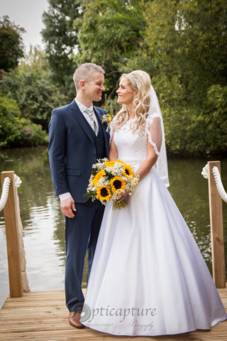 Bride and Groom standing by lake at Elm Farm Horsham St Faith Norfolk NR10 3HH