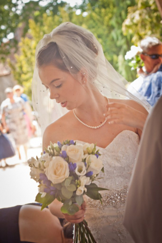 Bride looking to the side on way in to church at Watton
