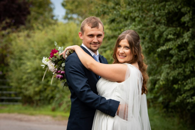Bride and Groom in embrace at Glebe Farm Barn NR9 4AP