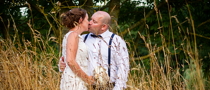 AlanBulldeathPhotographyBanner8 Bride and Groom kissing in a field at Broom Hall Watton